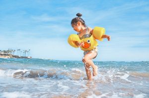 Girl wearing arm bands playing on a beach