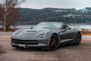Grey corvette next to a lake